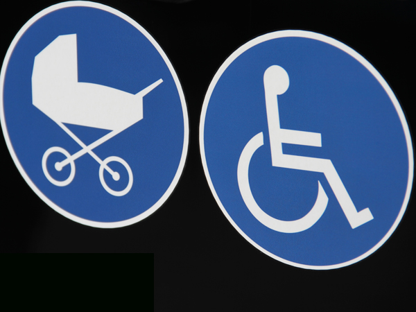 Zwei blaue Schilder mit einem Kinderwagen und einem Rollstuhlfahrer